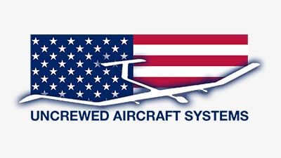 Logo featuring an American flag with white stars on a blue field and red stripes. Overlaid is a stylized outline of an aircraft. Text below the logo reads 